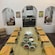 A wooden table set up for a cooking class with cutting boards, cheese graters, olive oil and bowls filled with various ingredients